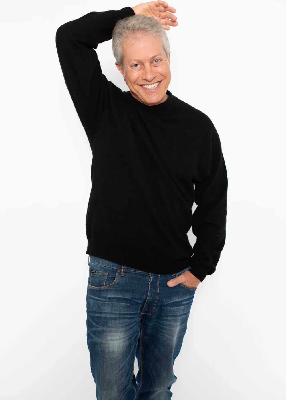 Scott Shimberg standing in black sweater and jeans arm above PNG